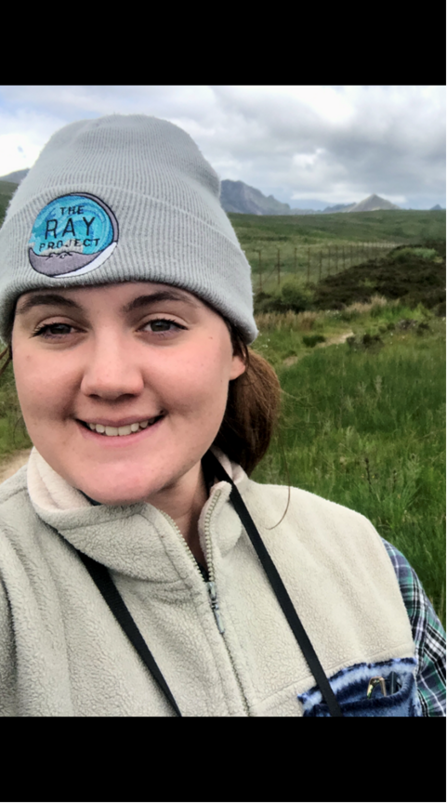 A woman in a beanie smiling at the camera.